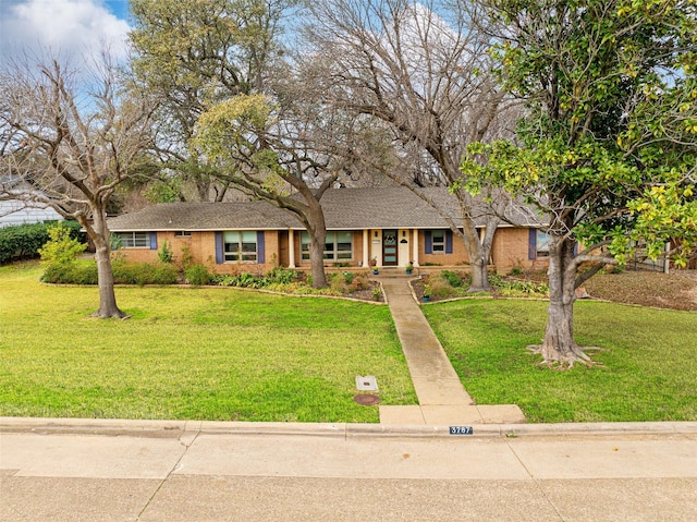 ranch-style house with roof with shingles, a front lawn, and brick siding