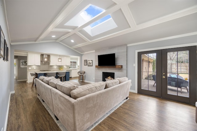 living room with lofted ceiling with skylight, french doors, dark wood-type flooring, and baseboards