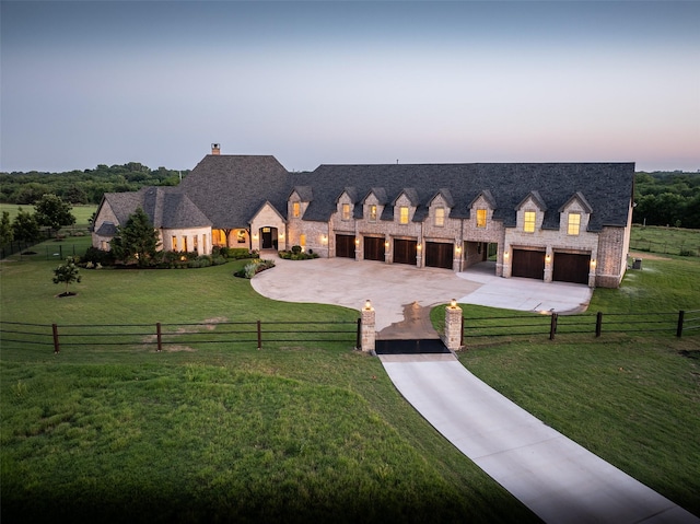 view of front of home with driveway, a front lawn, stone siding, and fence