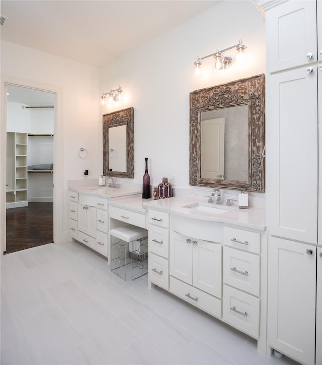 full bath with double vanity, visible vents, and a sink