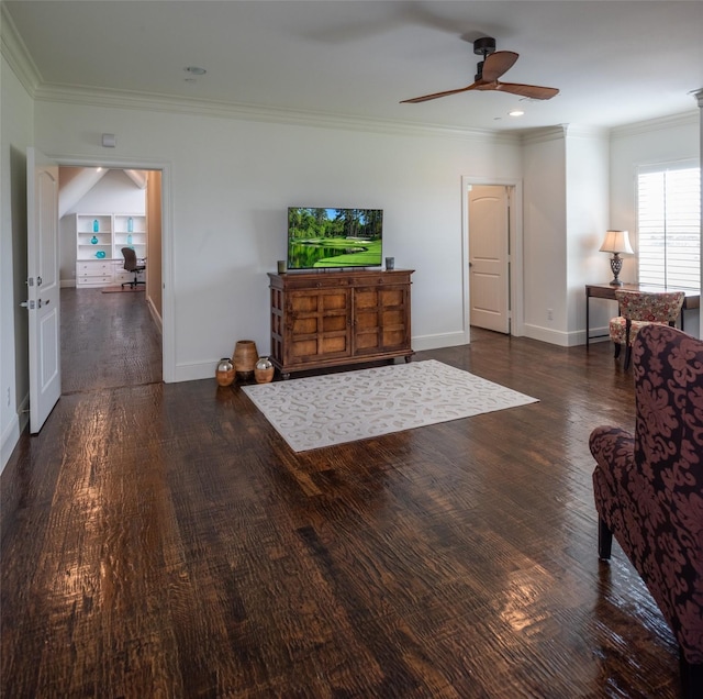 living area with baseboards, ornamental molding, and wood finished floors