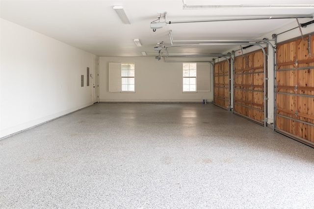 garage featuring a garage door opener and baseboards