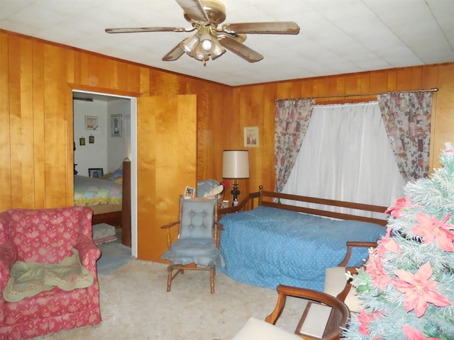 living area featuring ornamental molding, carpet flooring, a ceiling fan, and wooden walls