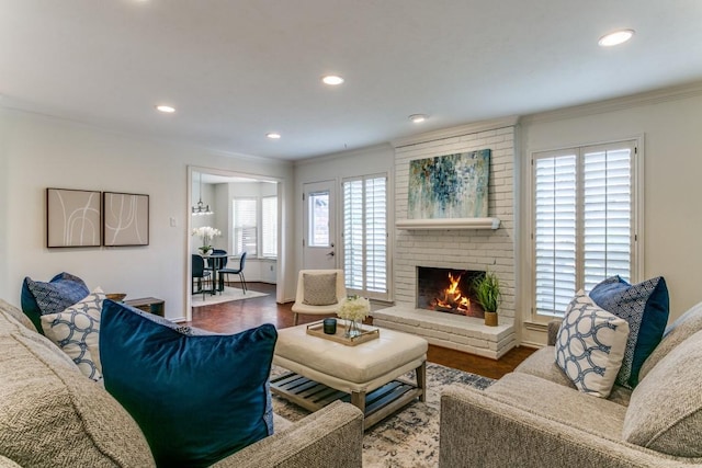 living area featuring crown molding, a fireplace, wood finished floors, and recessed lighting