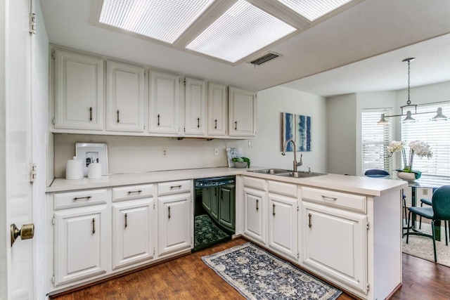 kitchen featuring black dishwasher, visible vents, dark wood-style floors, a peninsula, and a sink