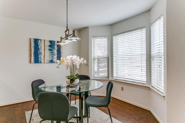 dining space featuring baseboards and wood finished floors