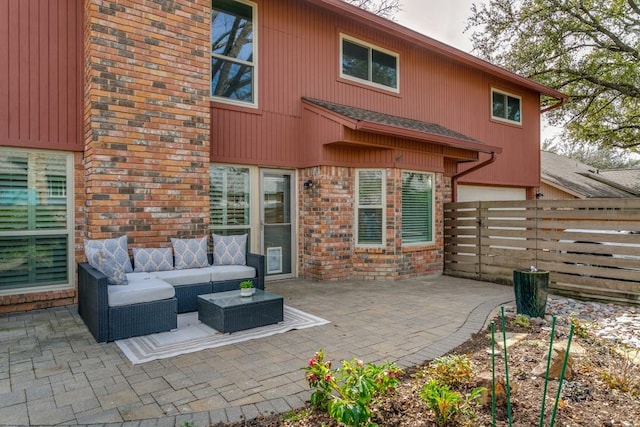 rear view of house with a shingled roof, fence, a patio area, an outdoor living space, and brick siding