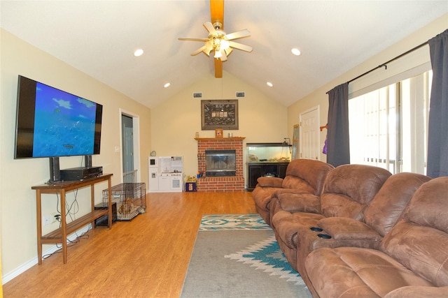 living room featuring vaulted ceiling with beams, a fireplace, a ceiling fan, wood finished floors, and baseboards