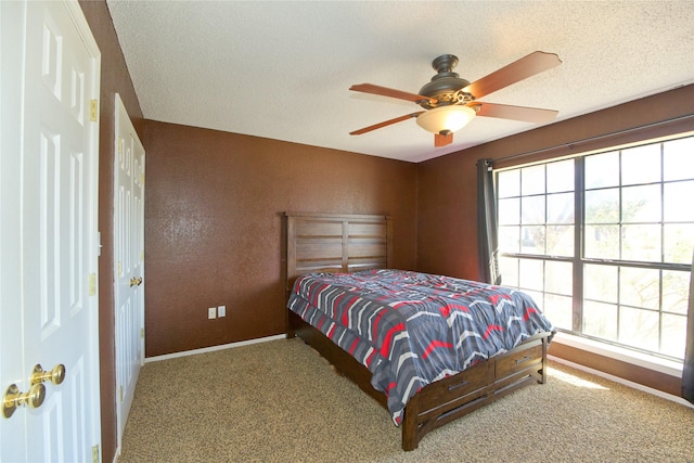 bedroom featuring carpet floors, ceiling fan, baseboards, and a textured ceiling