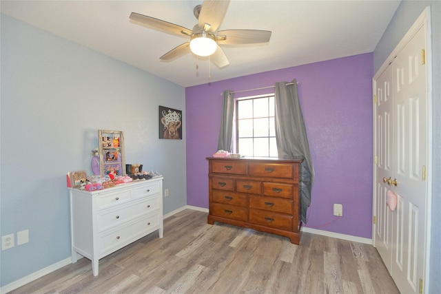 bedroom with light wood-style floors, a closet, baseboards, and a ceiling fan