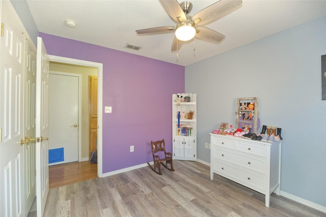 bedroom featuring baseboards, ceiling fan, visible vents, and light wood-style floors