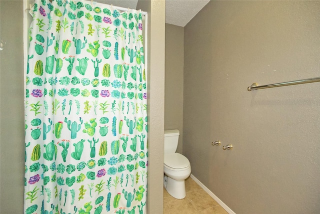 bathroom with curtained shower, toilet, a textured ceiling, baseboards, and tile patterned floors