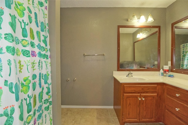 full bath featuring baseboards, a shower with shower curtain, vanity, and tile patterned floors