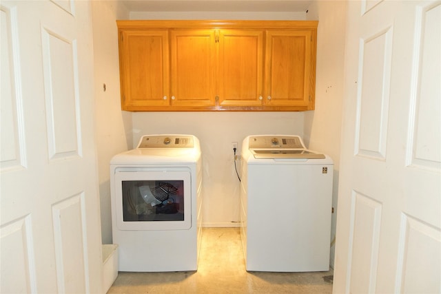 clothes washing area with cabinet space and independent washer and dryer