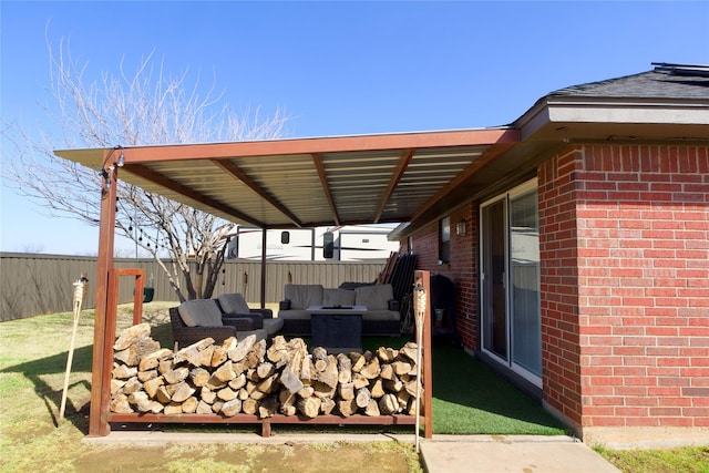 view of patio featuring an outdoor fire pit and fence