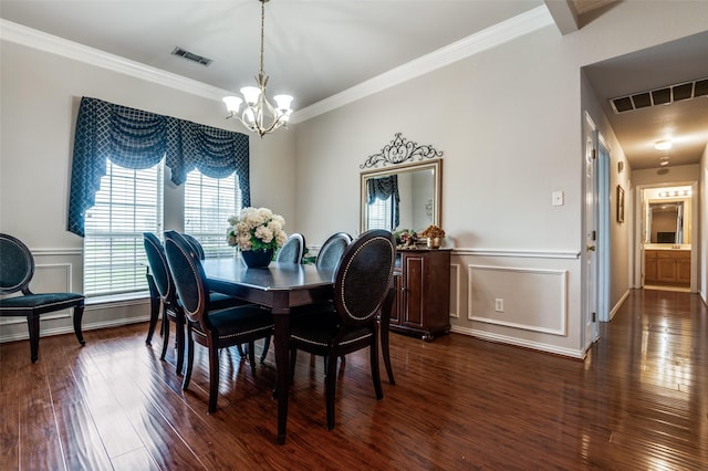 dining space featuring visible vents, dark wood finished floors, a notable chandelier, and a decorative wall