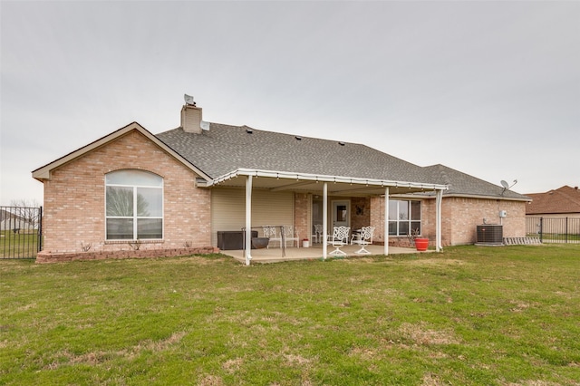 rear view of property with a yard, brick siding, and a patio