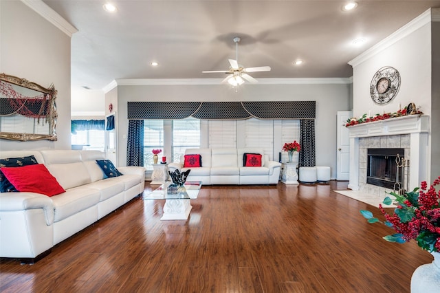 living room featuring a tiled fireplace, ornamental molding, wood finished floors, and recessed lighting