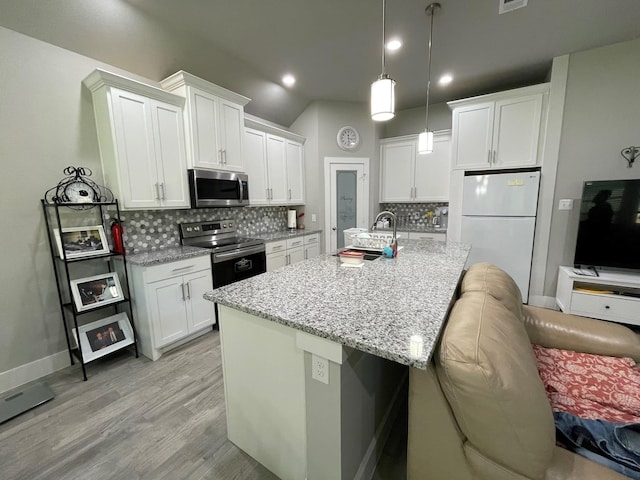 kitchen featuring a kitchen island with sink, stainless steel appliances, a sink, light wood-style floors, and white cabinets