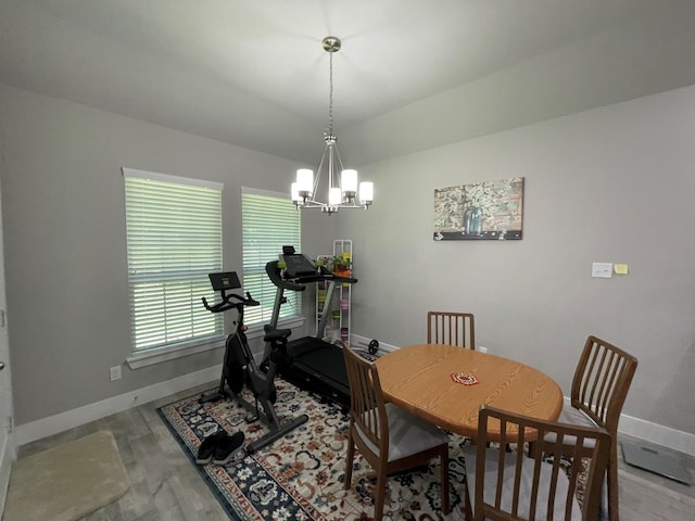 dining area with baseboards, a chandelier, and wood finished floors