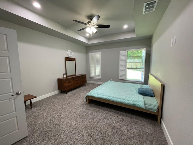 carpeted bedroom with baseboards, visible vents, ceiling fan, a tray ceiling, and recessed lighting