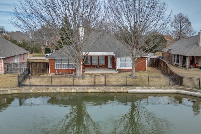 rear view of property featuring a fenced backyard, a lawn, a patio, and brick siding