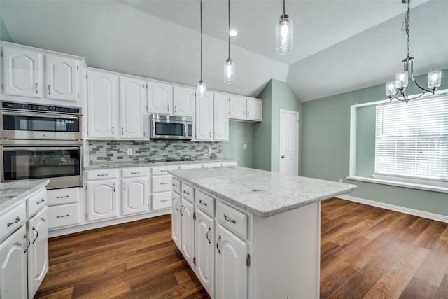 kitchen featuring lofted ceiling, white cabinets, appliances with stainless steel finishes, decorative backsplash, and dark wood-style floors