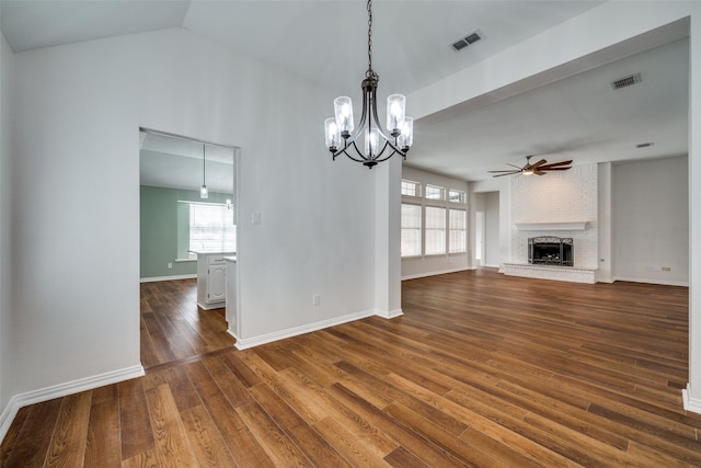 unfurnished living room featuring a brick fireplace, visible vents, dark wood finished floors, and ceiling fan