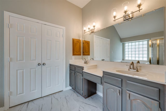 bathroom with lofted ceiling, marble finish floor, a sink, and double vanity