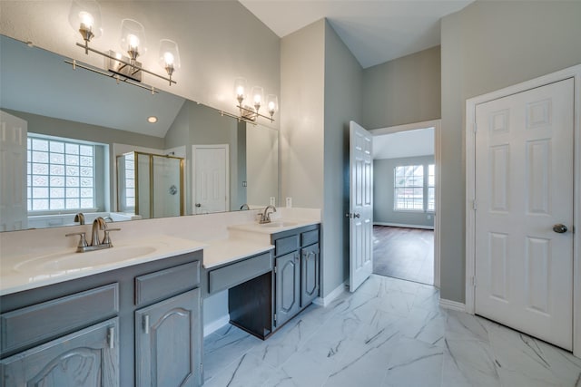 bathroom featuring a sink, vaulted ceiling, marble finish floor, double vanity, and a stall shower