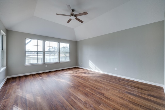 spare room featuring vaulted ceiling, dark wood finished floors, baseboards, and ceiling fan