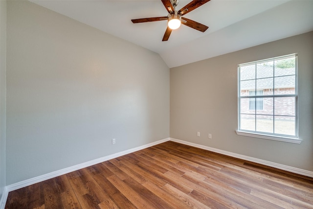 empty room featuring vaulted ceiling, ceiling fan, wood finished floors, and baseboards