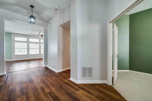 interior space with dark wood-style flooring, visible vents, and baseboards