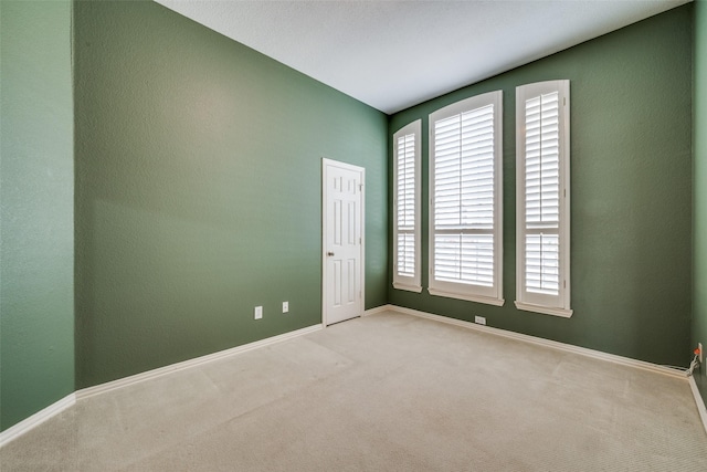 carpeted empty room with baseboards