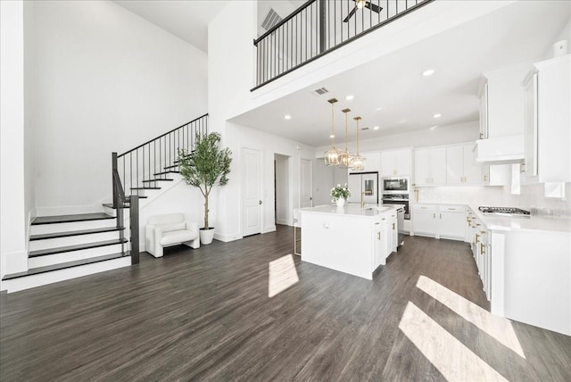 kitchen with stainless steel oven, built in microwave, light countertops, and dark wood-type flooring