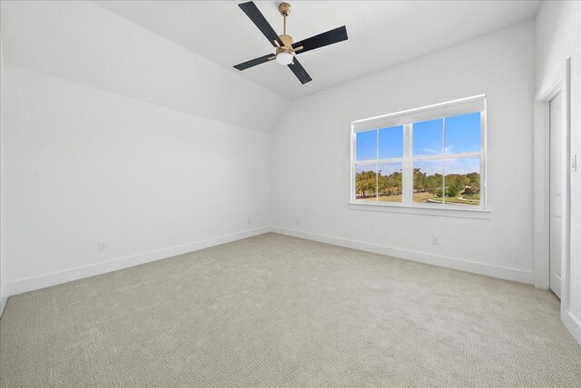 unfurnished bedroom featuring baseboards, ceiling fan, lofted ceiling, and light colored carpet