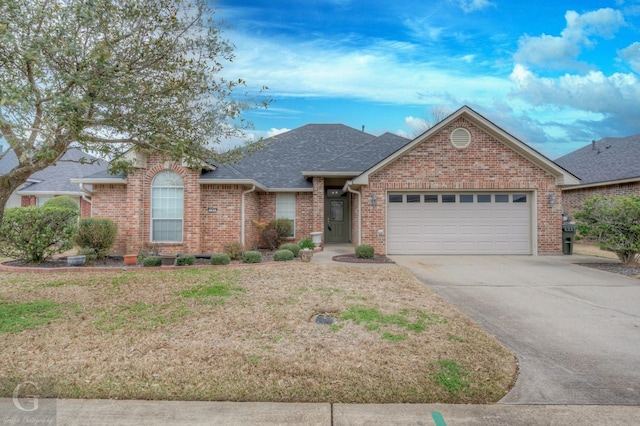 ranch-style home featuring roof with shingles, brick siding, concrete driveway, a front yard, and a garage