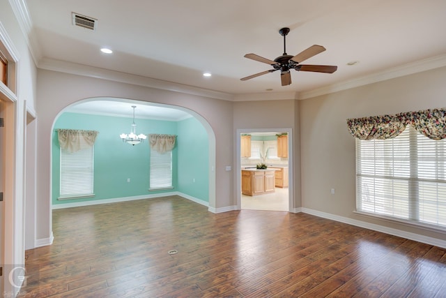 spare room with ornamental molding, wood finished floors, visible vents, and baseboards