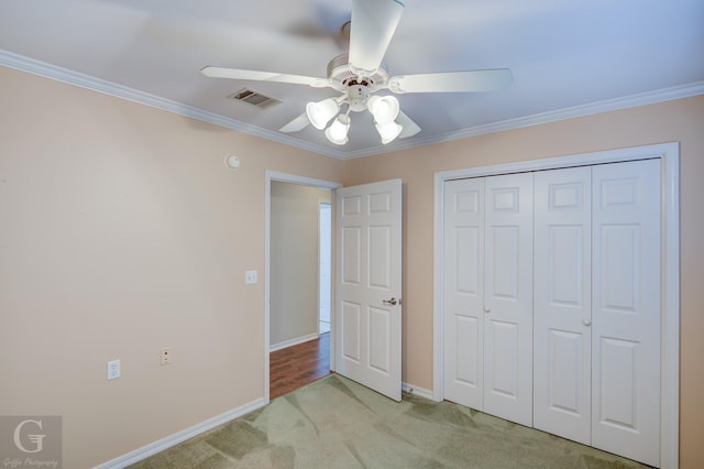 unfurnished bedroom featuring visible vents, baseboards, crown molding, and light colored carpet