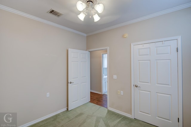 unfurnished bedroom with ornamental molding, light carpet, visible vents, and baseboards