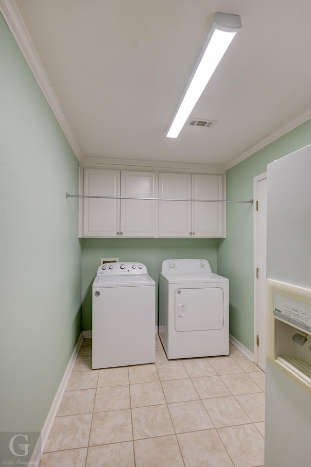 laundry area featuring ornamental molding, light tile patterned flooring, cabinet space, and separate washer and dryer