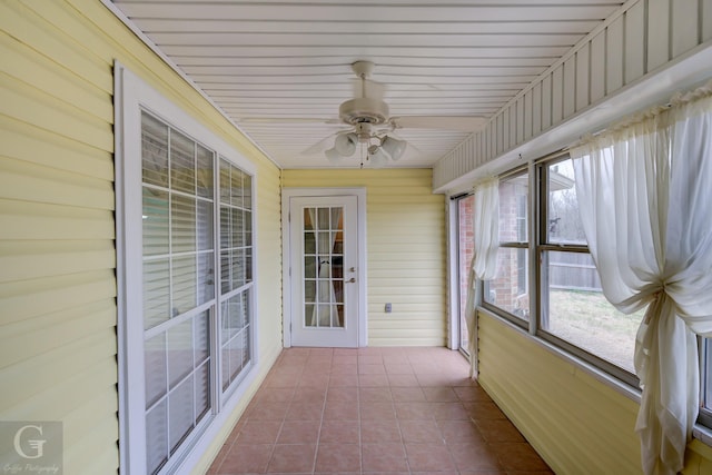 unfurnished sunroom featuring a ceiling fan