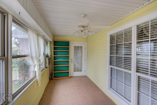 unfurnished sunroom featuring a healthy amount of sunlight and a ceiling fan