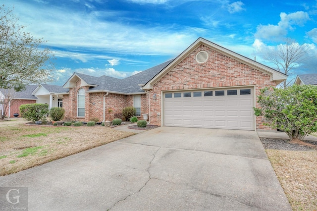 ranch-style home featuring driveway, brick siding, roof with shingles, and an attached garage