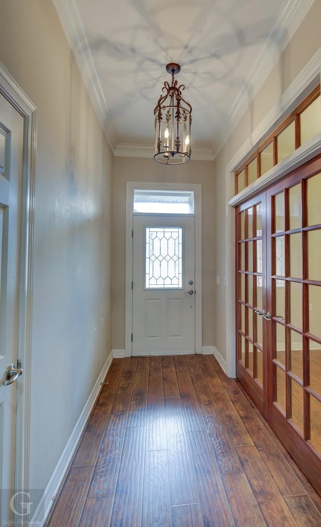 entryway featuring hardwood / wood-style flooring, a notable chandelier, baseboards, and crown molding