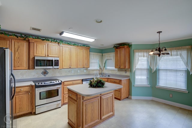 kitchen featuring stainless steel appliances, a sink, visible vents, light countertops, and a center island