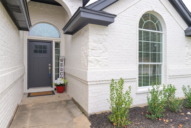 entrance to property featuring brick siding