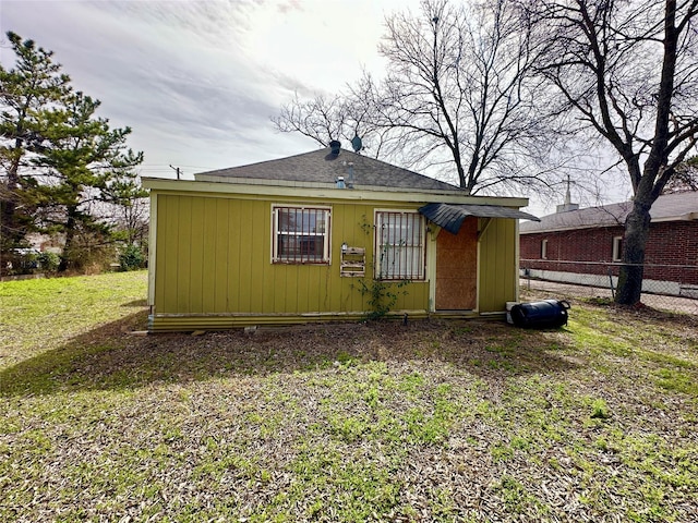 rear view of property with a yard and fence