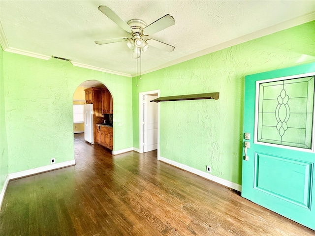 empty room featuring arched walkways, a textured wall, and visible vents