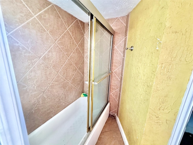 bathroom with a shower with shower door, a textured wall, a textured ceiling, and tile patterned floors